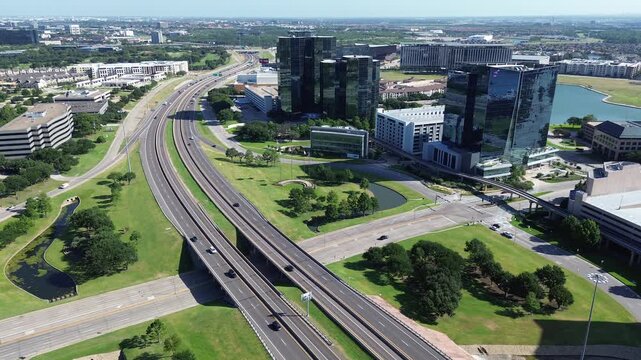 Elevated transit rails connect dense corporate glass towers and serene waterfront landscapes in Las Colinas, Irving, Texas. Future forward planning defines unique character of infrastructure