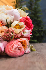 Close up of beautiful wedding bouquet with peonies resting on rustic wooden table. © Olga