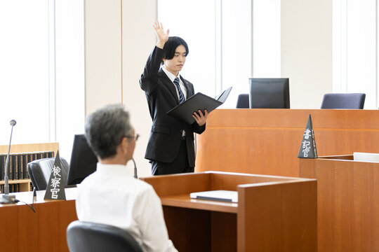法廷で宣誓する若い検察官