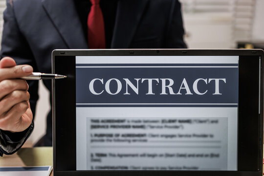 Business person pointing at a laptop screen a contract document during a meeting, close up of legal and office work