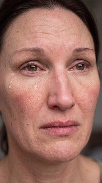Portrait einer weinenden dunkelhaarigen Frau, die Augen geschwollen und ger&ouml;tet. Tr&auml;nen laufen &uuml;ber ihr Gesicht. 
