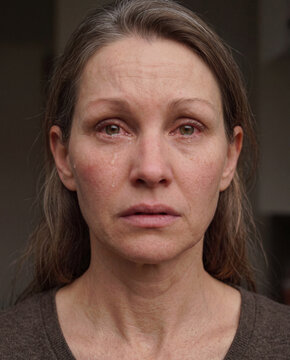 Portrait einer weinenden dunkelhaarigen Frau, die Augen geschwollen und ger&ouml;tet. Tr&auml;nen laufen &uuml;ber ihr Gesicht. 