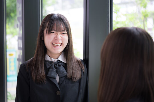 笑顔で会話を楽しむ女子高校生2人　休み時間や放課後の学校生活・友人とのコミュニケーション、青春のイメージ