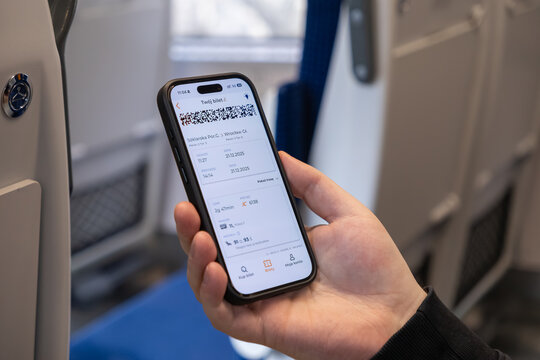 Szklarska Poreba, Poland - December 21, 2025: A passenger holding a smartphone with an electronic train ticket to travel, representing modern mobility and digital transit