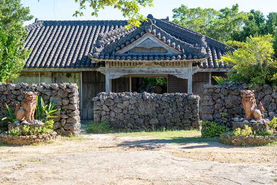 Traditional Okinawan House with Red Tile Roof and Shisa Statues