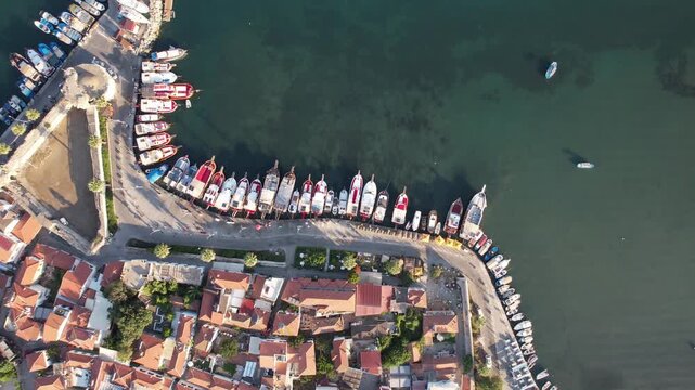 Aerial view flying over the scenic coastal town of Sigacik, with boats moored in the harbor,fa01