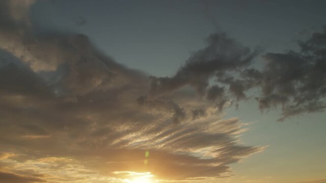 Timelapse sunset sky with layered stratocumulus clouds and glowing horizon light
