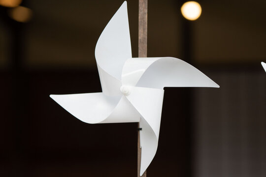 White Pinwheel on Wooden Pole with Blurred Bokeh Lights