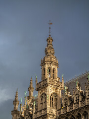 Fototapeta premium Historic Gothic tower viewed from Grand Place against dramatic overcast sky.