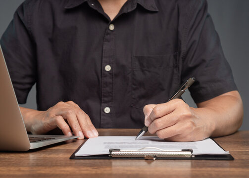 Reviewing and Signing Paper Document at Desk