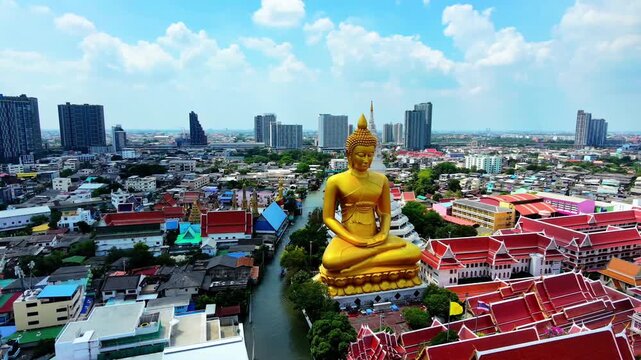 Aerial view panning left to right showing Giant Golden Buddha statue at Wat Paknam Phasi Charoen, Bangkok, Thailand