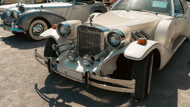 Cream Excalibur neoclassical car at oldtimer show.