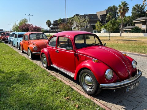 A row of classic Volkswagen Beetle cars parked along a street in the coastal resort area near Kemer, Antalya Province