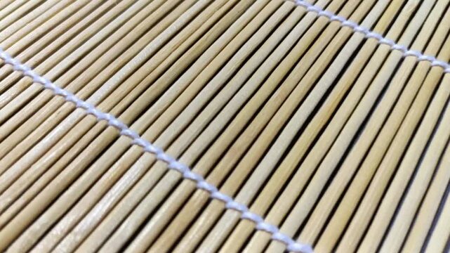 Close up panning shot of a traditional bamboo sushi rolling mat texture