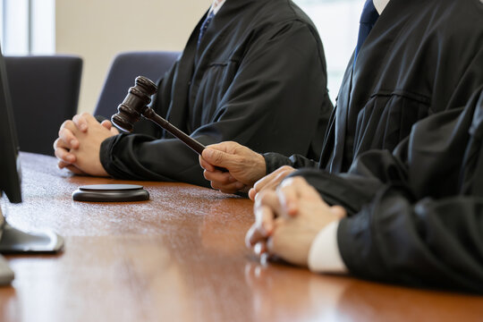 法廷で木槌を打つ裁判官の手元クローズアップ