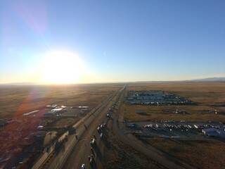Fototapeta premium High resolution aerial drone view of a major interstate highway crossing an open desert landscape during sunset. Commercial transportation, freight logistics, road infrastructure, travel and supply ch