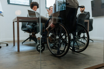 Obraz na płótnie Canvas Wheelchair user participating in office business meeting