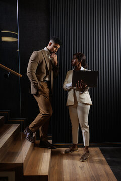 Professionals discussing business strategy walking up office stairs
