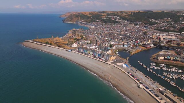 Wide aerial view of coastal town beach harbor and hills
