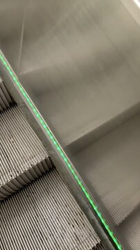 Escalator Steps Moving with Green Light Strip Close-up