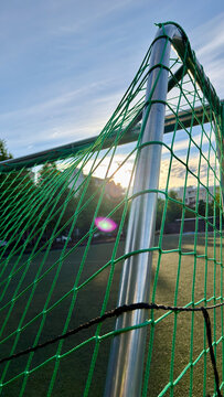 Soccer Goal Post and Green Net Against Evening Sun Close-up