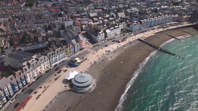 People relaxing strolling promenade beach seafront aerial drone view