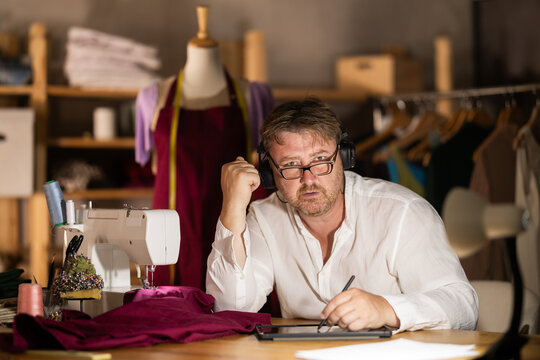 Male tailor create sketch of dress on tablet