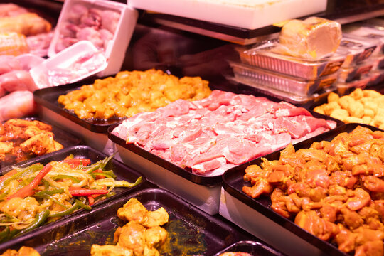 Meat department of store sells chicken meat and vegetables marinated with addition of spicy seasoning