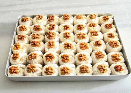 Unbaked B&uuml;lb&uuml;l Yuvası Nightingale Nest Baklava Pastry with Walnuts Full Frame.
Traditional Turkish Sweet Pastry Made of Phyllo Dough and Topped with Walnut Halves Close Up