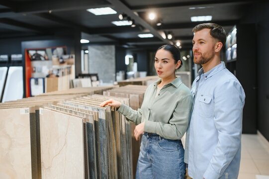 Couple choosing ceramic tiles in a bathroom furniture store