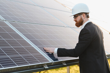 Fototapeta premium Engineer touching solar panel in solar power plant