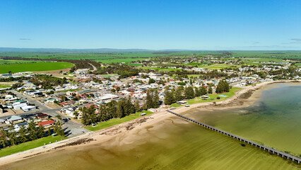 Port Broughton, Yorke Peninsula, South Australia – 4K aerial drone view of foreshore, jetty, beach, seaside township, residential houses, Norfolk pines, Spencer Gulf coastline and farmland © Thomas
