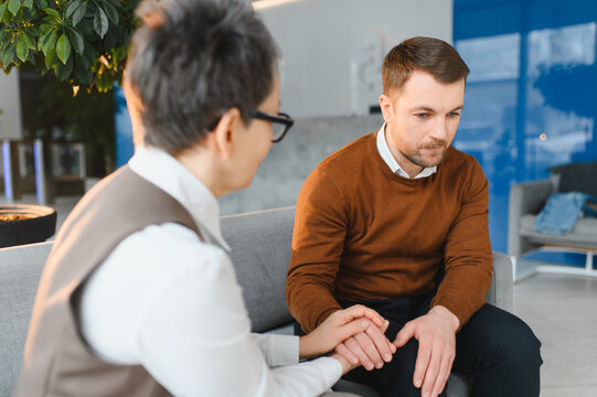 Psychologist comforting sad client during therapy session