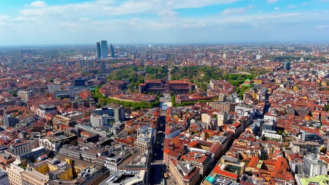 Aerial view of Milan, Italy, along the Via Dante axis toward Castello Sforzesco, with Sempione Park, the CityLife skyscrapers, red rooftops and the urban plain on a spring day.