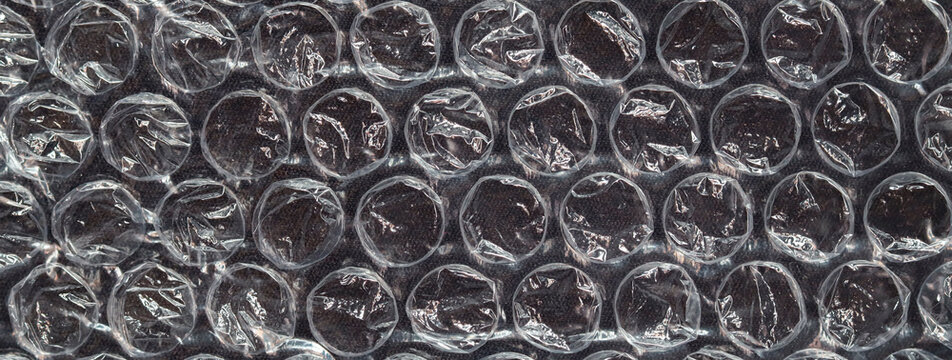 Close-up of transparent bubble wrap plastic texture used for protective packaging and cushioning fragile items during shipping and storage.