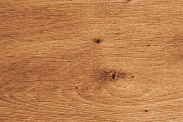 Obraz premium Horizontal close up overhead view of a warm golden brown wood texture with natural oak grain rings and rustic timber knots for vintage background design