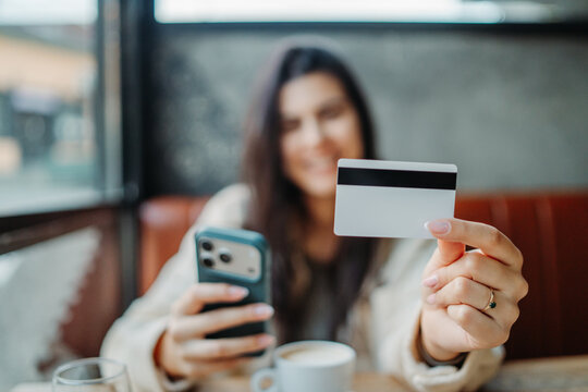Woman holding credit card and smartphone for online payment
