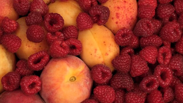 Fruit and berry plate. Mix fruits and berries apricot, peach, raspberry close up, rotation