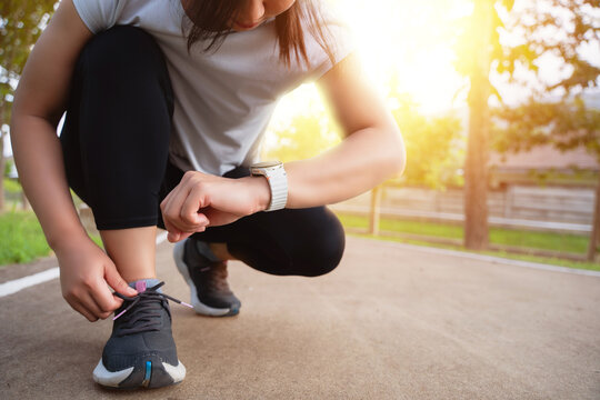 The young woman monitors her heart rate via an application on her smartwatch. The concept involves exercising for health, such as running and walking.
