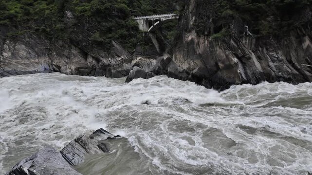 Raging River in Tiger Leaping Gorge with Arch Bridge
