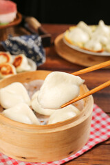 Fototapeta premium Handmade Chinese Dumplings in Bamboo Steamer with Chopsticks - Traditional Asian Cuisine