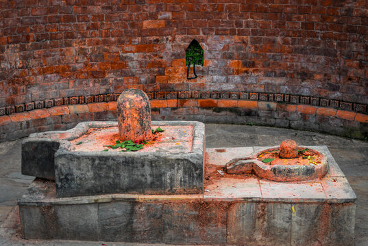 Two traditional Shiva Lingas within Yoni bases inside a historic shrine at Pashupatinath Temple in Kathmandu, Nepal, showcasing sacred Hindu symbolism, religious architecture, and cultural heritage