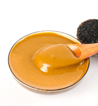 Pure Golden Sesame Sauce in Bowl with Wooden Spoon - Hot Dipping Sauce for Asian Cuisine