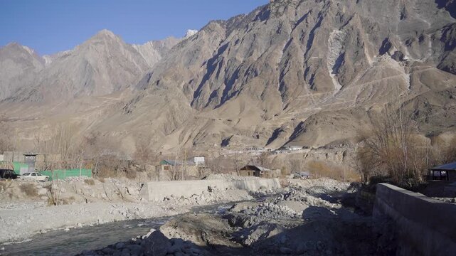 Drone tracking shot of a flowing mountain stream through a rocky valley in Chitral Pakistan