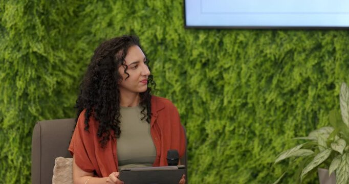 Diverse female panelists holding tablet, shifting gaze and passing microphone, presenting VR slides