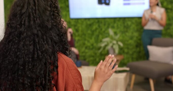 Attendee raising hand with gold bangle asking at panel while presenters holding mics, copy space