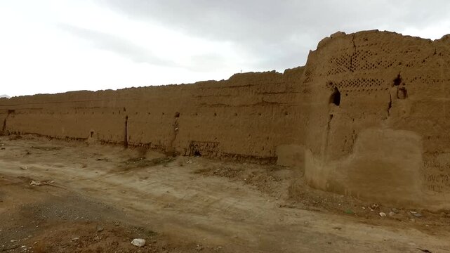 Aerial drone view of an ancient village castle constructed from mud bricks and clay, capturing historical fortress towers and traditional middle eastern desert architecture stock video asset.