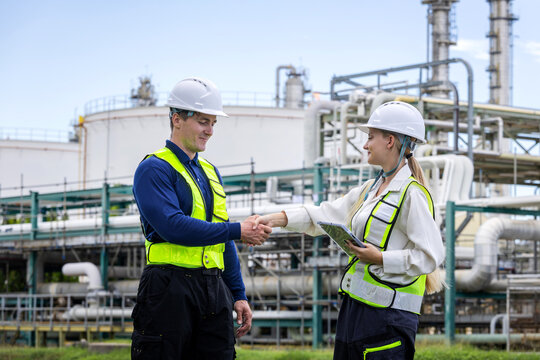 Engineers team shaking hands at oil refinery plant facility, Professional refinery supervisors agreeing on project at oil and gas plant, Worker team celebrating partnership at industrial site