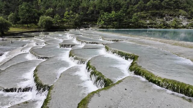 Travertine Terraces with Turquoise Water Cascades and Forest Hillside