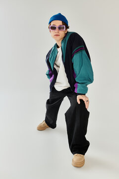 A young college student poses confidently in a trendy bomber jacket, embracing contemporary youth culture.